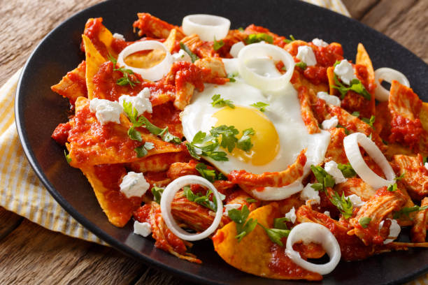 istock Mexican chilaquiles with fried egg and chicken close-up. horizontal 985118586