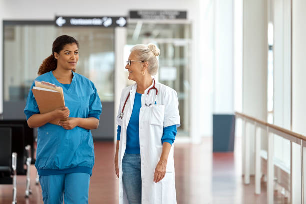 istock Female Medical Professionals Talking In Corridor 985125876