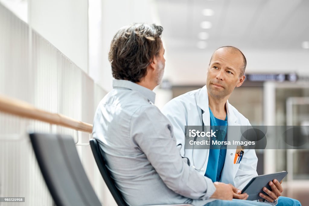 Medico consulente paziente maschio in sala d'attesa - Foto stock royalty-free di Medico