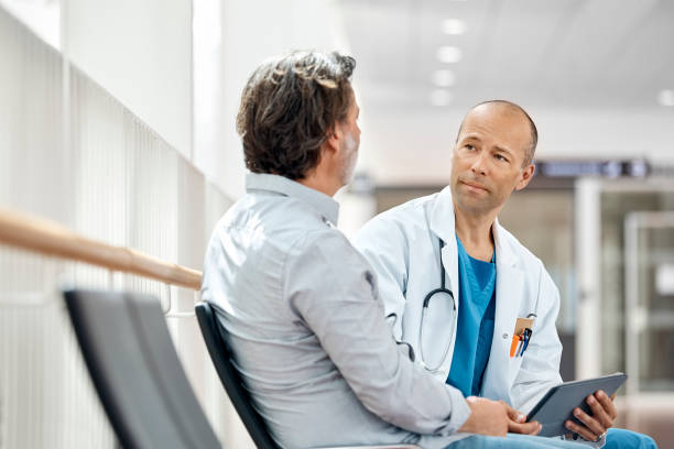 doctor counseling male patient in waiting room - outpatient imagens e fotografias de stock