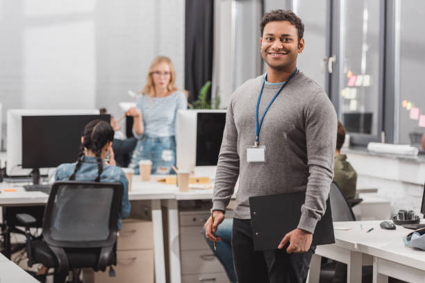istock happy african american man with name tag and planchette at modern office 985126130