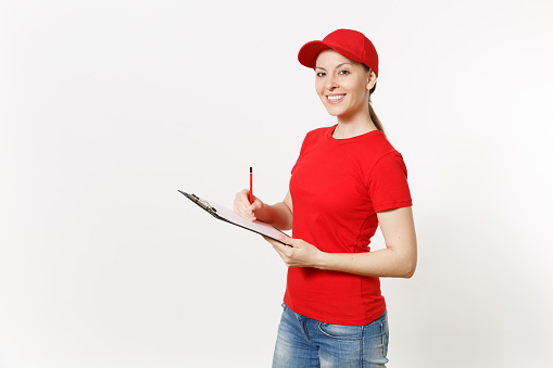 Delivery woman in red uniform isolated on white background. Female in cap, t-shirt, jeans working as courier or dealer, holding pen, clipboard with papers document, with blank empty sheet. Copy space