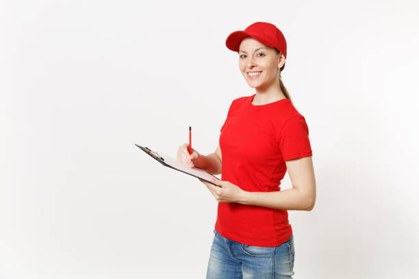 доставка женщина в красной форме изолированы на белом фоне. самка в кепке, футболке, джинсах, работающих курьером или дилером, держащая ручк - red cap стоковые фото и изображения