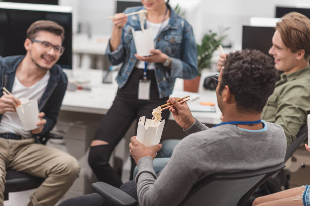 istock multicultural people eating thai food at modern office 985128650