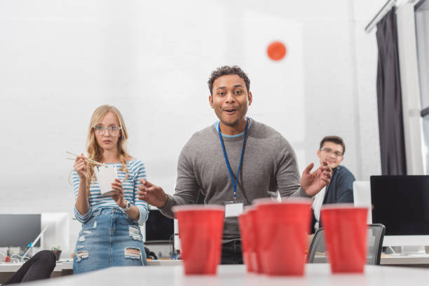 istock young attractive people playing beer pong at modern office after work 985130256