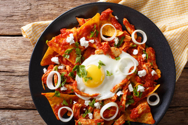istock Mexican breakfast: chilaquiles with egg and chicken close-up. horizontal top view 985133842