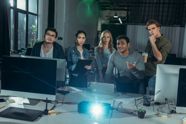 istock young people watching presentation in modern office at nighttime 985138770
