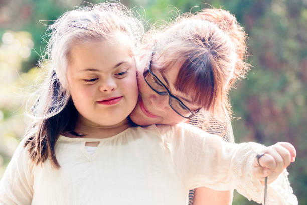 portrait d’une mère avec sa fille de 12 ans atteints d’autisme et le syndrome de down dans la vie quotidienne - 45 49 years photos et images de collection