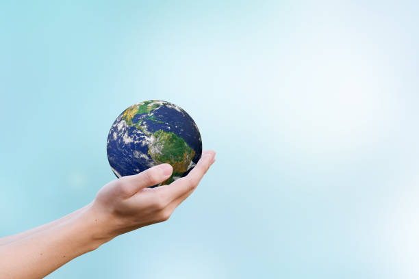 istock Two hands holding the earth in palm gesture on blurred blue map color gradient background.Elements of this image furnished by NASA 985144380