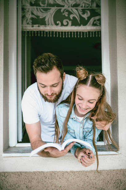istock Older Brother Reading Story To Sister 985144554