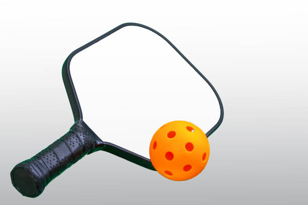 istock Black and White Pickleball Paddle with Orange ball. 985144594