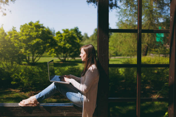 Young successful businesswoman in light casual clothes. Smiling Woman working on modern laptop pc computer in city park in street outdoors on spring nature. Mobile Office. Freelance business concept. Young successful businesswoman in light casual clothes. Smiling Woman working on modern laptop pc computer in city park in street outdoors on spring nature. Mobile Office. Freelance business concept niñas stock pictures, royalty-free photos & images