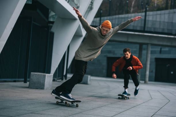 istock handsome young men riding skateboards in urban location 985151122
