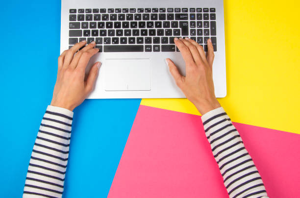 istock Woman hands using laptop on colorful background 985155020
