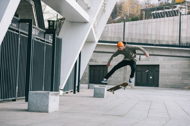 istock skateboarder performing jump trick in urban location 985158786