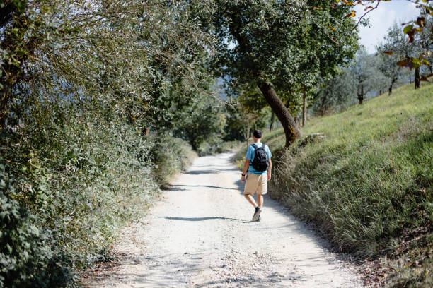 istock A man walking on a road in tuscany, Italy 985159330