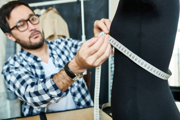 istock Man designing dress with mannequin 985161882