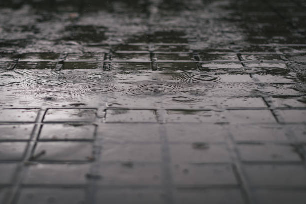 istock Rain falling down a urban outdoor city squared floor ground 985161990