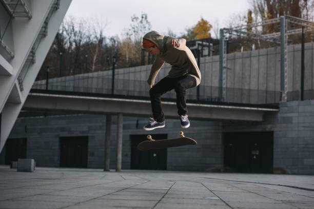 istock young skateboarder performing jump trick in urban location 985162866