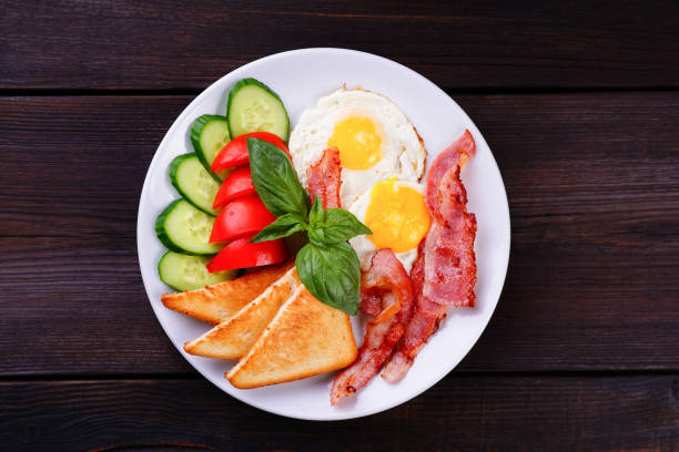 istock Continental breakfast. Fried eggs with bacon, toasts and fresh v 985166126