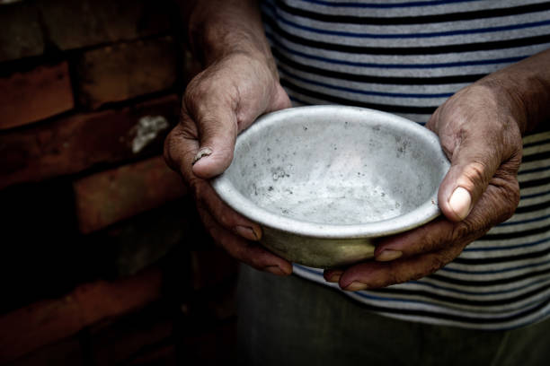 the poor old man's hands hold an empty bowl. the concept of hunger or poverty. selective focus. poverty in retirement.homeless. alms - fome imagens e fotografias de stock