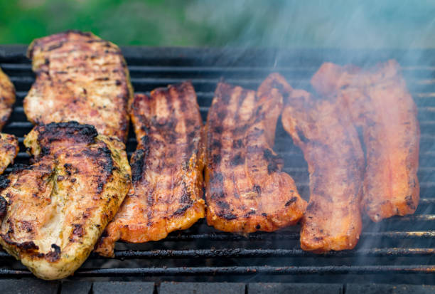 istock Assorted mixed grill from chicken meat, and pork, sausages  roasting on barbecue grid cooked for summer family dinner 985170980