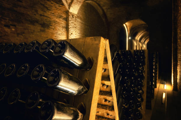 pupitre and wine bottles inside an underground cellar - aging process french culture winemaking next to imagens e fotografias de stock