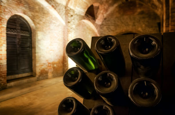 bouteilles de vin et pupitre à l’intérieur d’une cave - aging process french culture winemaking next to photos et images de collection