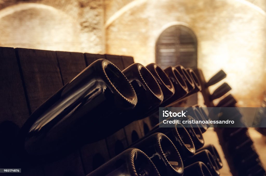 Pupitre and wine bottles inside an underground cellar Pupitre and bottles inside an underground cellar for the production of traditional method sparkling wines in italy Champagne Stock Photo