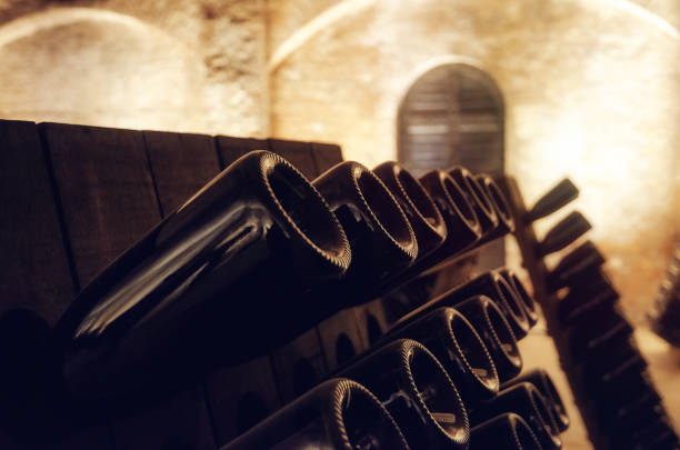 pupitre and wine bottles inside an underground cellar - aging process french culture winemaking next to imagens e fotografias de stock