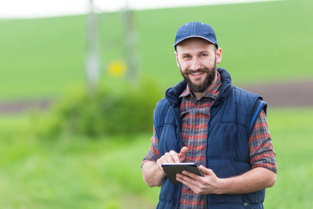 istock Smiling young man with tablet on country road 985181310