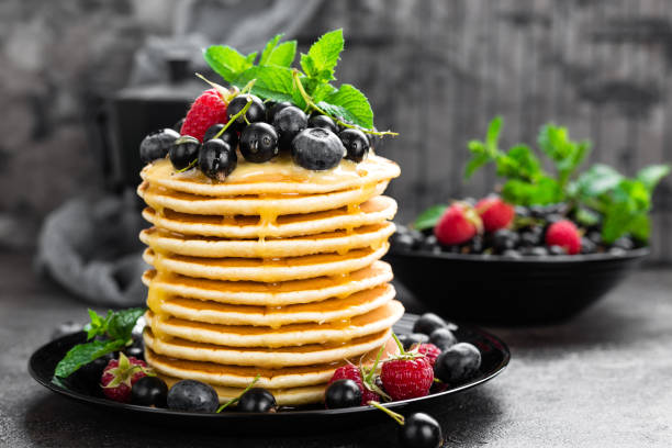 istock Pancakes with fresh berries. Pancakes with raspberry, blueberry, black currant and honey 985184328