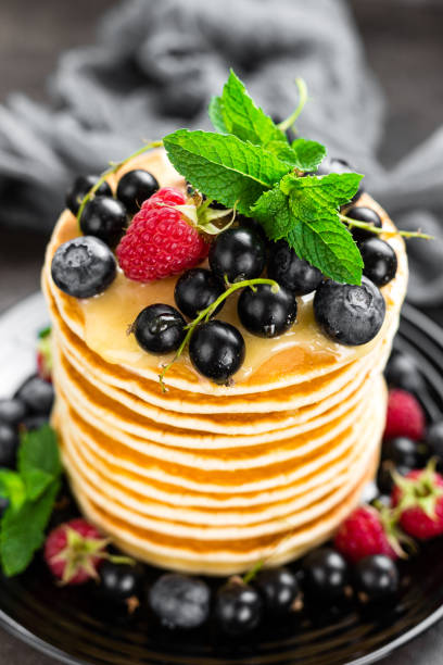 istock Pancakes with fresh berries. Pancakes with raspberry, blueberry, black currant and honey 985184598