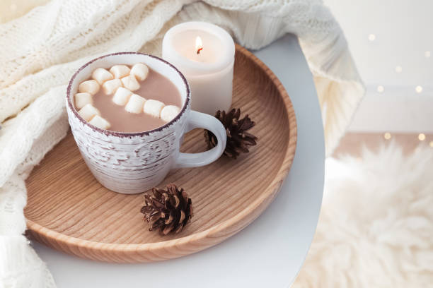 istock Hot cocoa with marshmallows, knitted sweater and burning candle 985187674