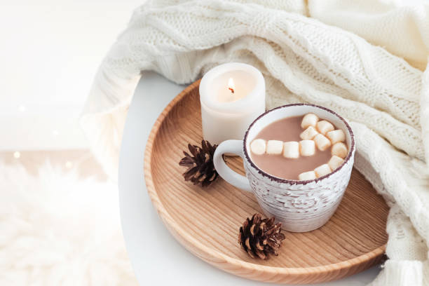 istock Hot cocoa with marshmallows, knitted sweater and burning candle 985187712