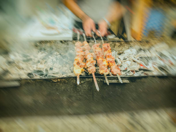 istock Marinated shashlik preparing on a barbecue grill over charcoal.  Traditional roasted stacked meat Shish kebab popular in Goergia. Blure effect 985195968