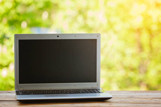 istock Notebook on wooden table and nature background 985209582
