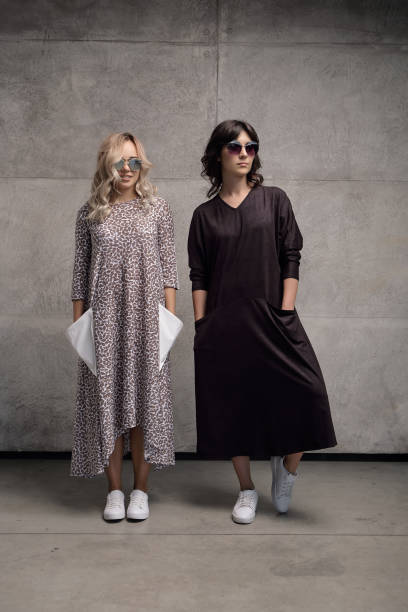 istock Two cheerful trendy young women wearing sunglasses 985238152