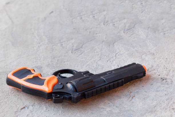 ジーンズのポケットのプラスチック銃を持った少年。おもちゃで幸せな少年は、夏の日に屋外で遊ぶ銃をピストルします。 - toy gun ストックフォトと画像
