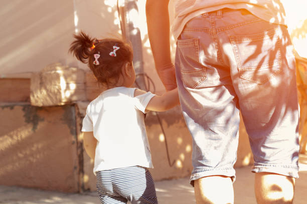 istock Back view of father and child walking. 985239020