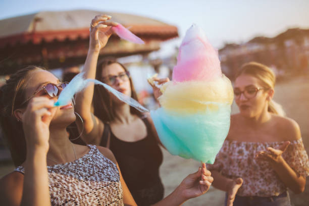Girls eating cotton candy at the county fair Girls having fun with cotton candy at the county fair in summer child cotton candy stock pictures, royalty-free photos & images