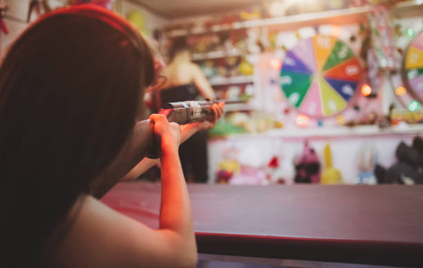 Brunette girl shooting for a prize at county fair at night