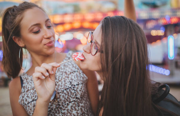istock Girl sharing lollipop with her friend 985263468