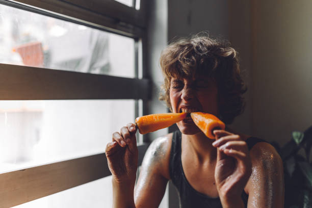istock Woman eating bell pepper 985266312