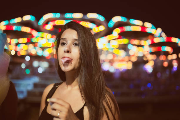 istock Girl eating candy cotton in amusement park 985267438