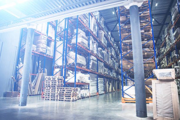 istock Industrial warehouse and logistics concept. Large storage with racks, shelves, boxes, containers and other goods. Interior with perspective 985280536