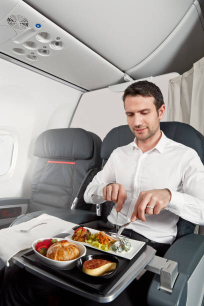 Having airplane food Young man having airplane food in an airplane cabin airplane food stock pictures, royalty-free photos & images