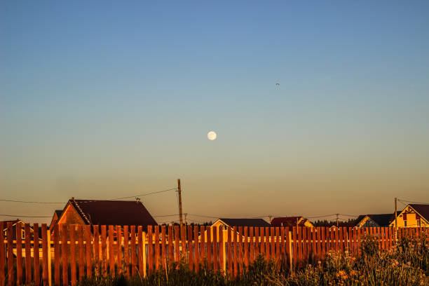 sunset in the village and the moon in the blue sky - barn farm moon old imagens e fotografias de stock