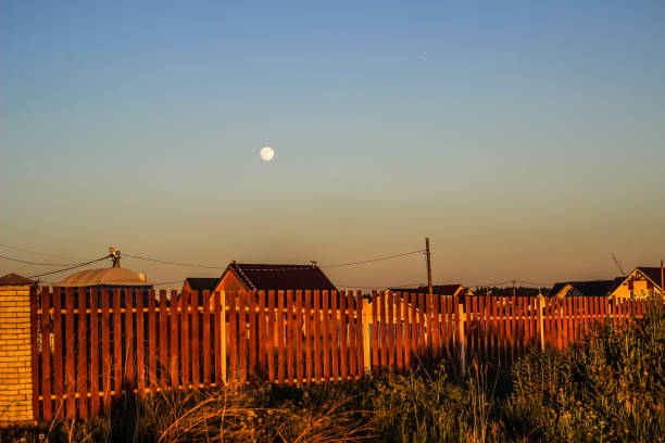coucher de soleil dans le village et la lune dans le ciel bleu - barn farm moon old photos et images de collection