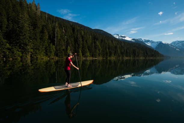 istock Woman paddling on a stunning mountain lake 985287914